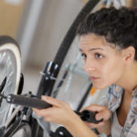 female bike technician pumping up a bike