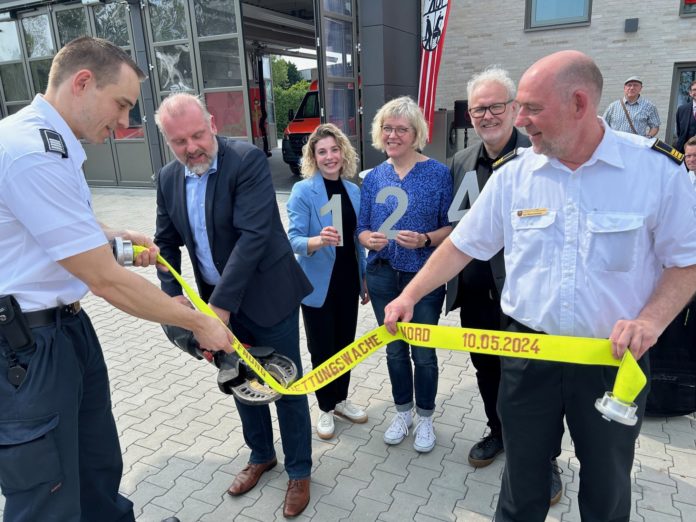 Stefan Fahrenbach (Feuerwehr Unna, links) und Olaf Weischenberg ( Amtsleiter Feuerschutz und Rettungswesen Kreisstadt Unna) halten den symbolischen Löschschlauch, den Bürgermeister Dirk Wigant (2.von links) symbolisch mit einer Hydraulikschere durchschnitt. Im Hintergrund halten Sophe Schulte Filthat (Lindner Lohse Architekten BPA), Nadja Lüke (Immobilenmanagement Kreisstadt Unna) und Harald Lindner als ausführender Architekt (von links) die Hausnummer der neuen Rettungswache hoch. Foto Stadt Unna